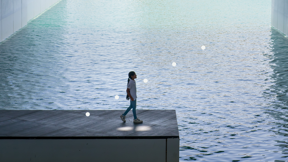 A girl surrounded by water looks up