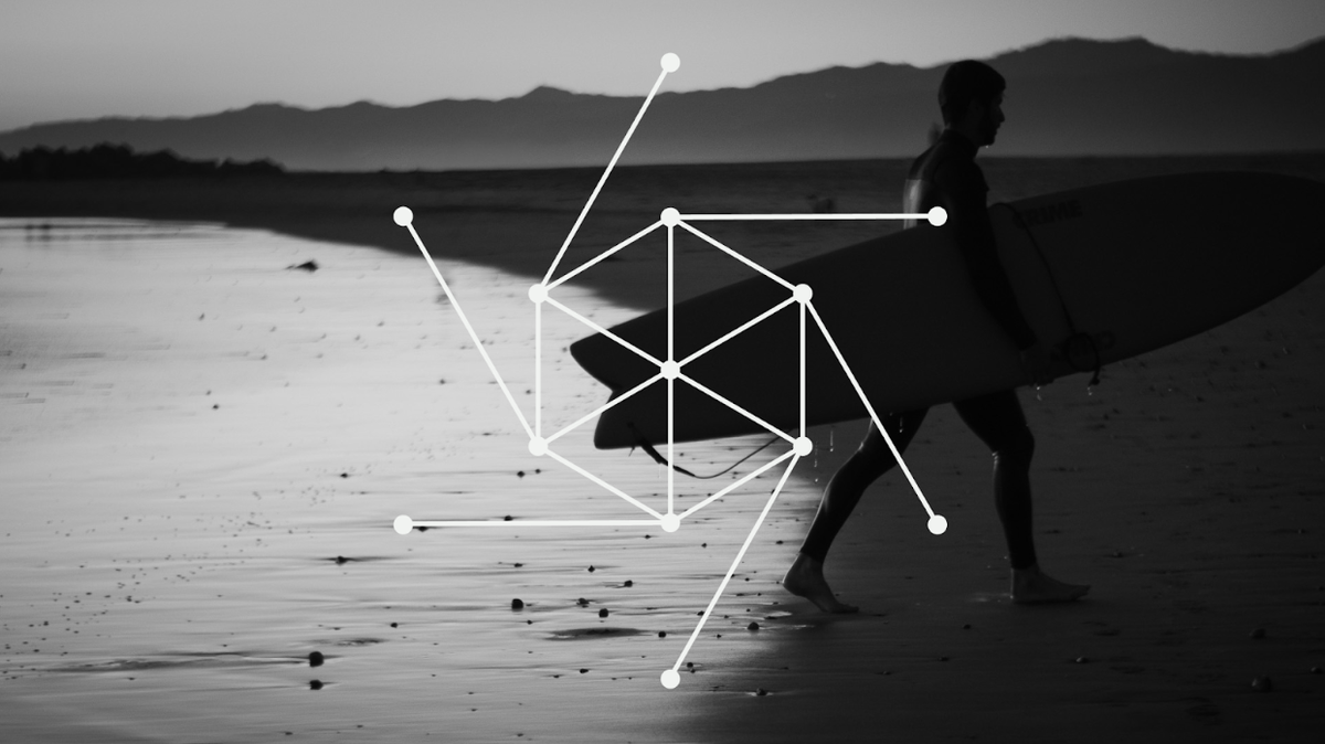 Photograph of a surfer walking out of the ocean carrying his board.