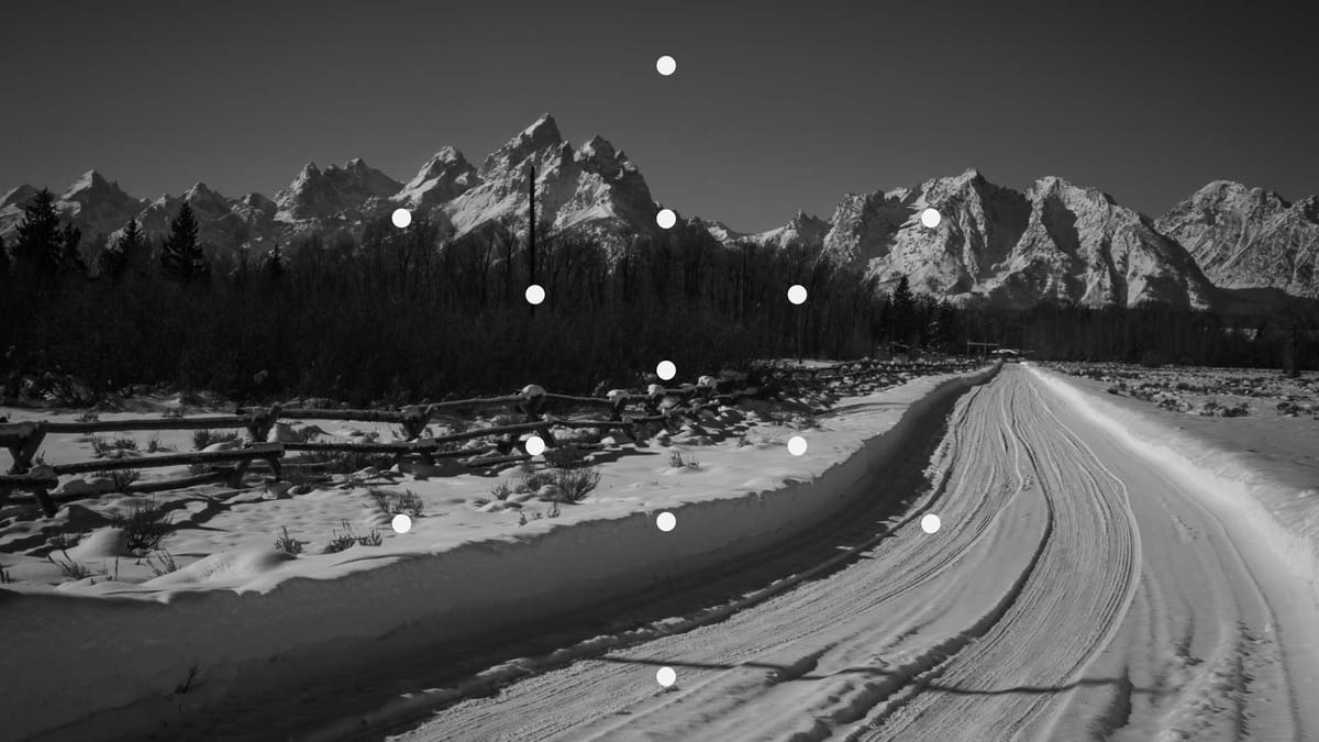 Photo of a snowy road leading to snowy mountains, overlaid with dots.